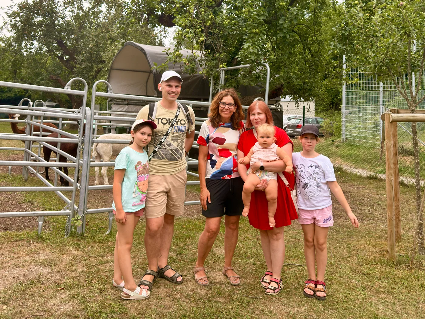 Anna-Mariia Kostiuk mit Familie und der Leiterin der Alpaka Alm Leonberg vor dem Gehege
